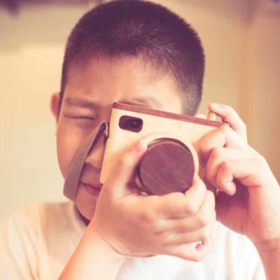 enfant qui prend une photo avec son appareil photo numérique
