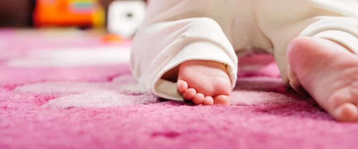 bébé sur un tapis enfant rose