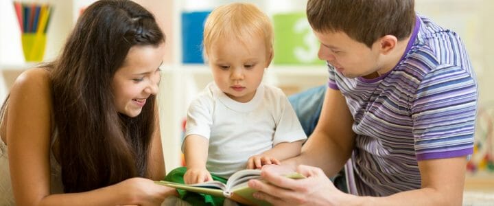 parents avec leur bébé lisant un livre à toucher