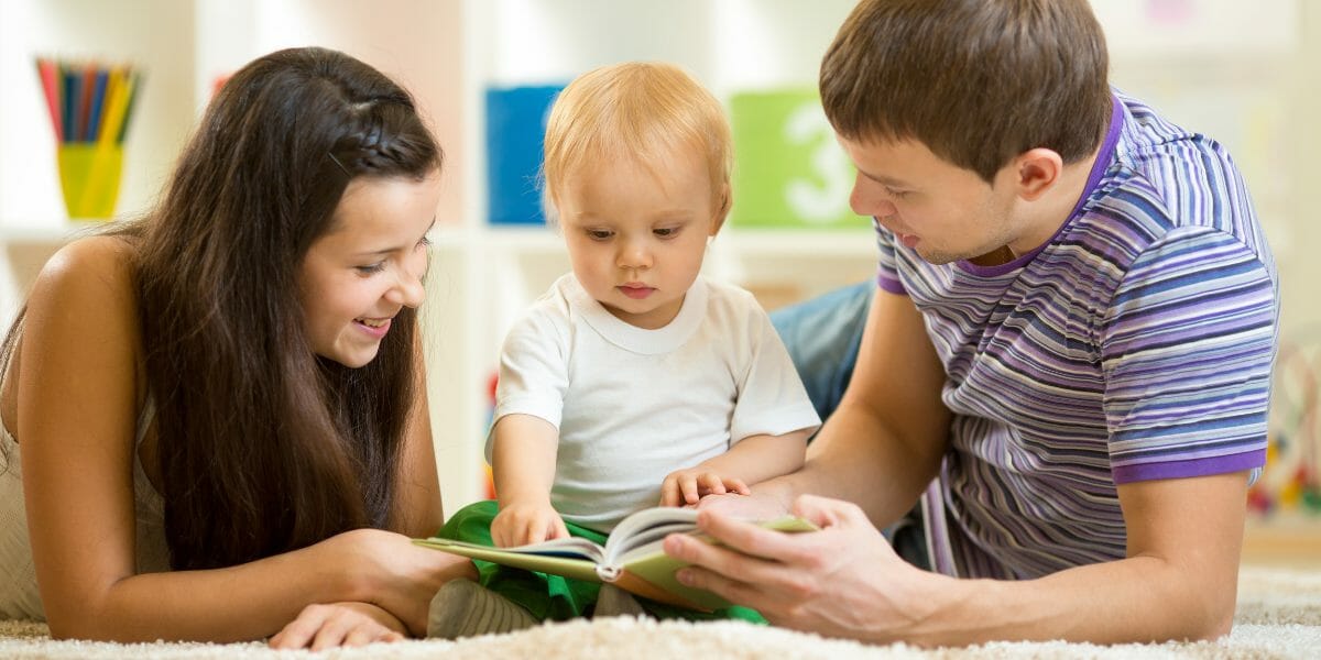 parents avec leur bébé lisant un livre à toucher