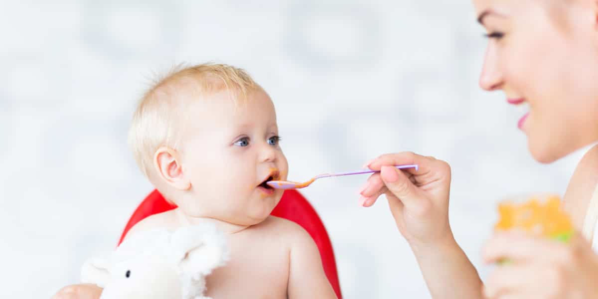 Mother feeding baby with spoon