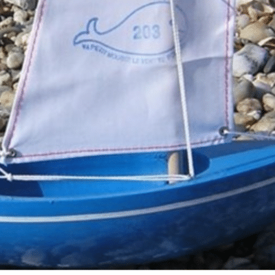 bateau bleu avec voile blanche marque Tirot