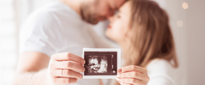 Un couple amoureux de futurs parents montre une photo d'une échographie