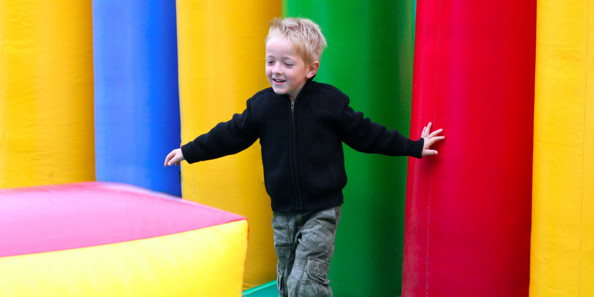 petit garçon joue sur une aire de jeux gonflable