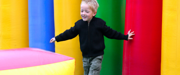 petit garçon joue sur une aire de jeux gonflable