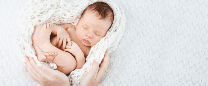 bébé enroulé dans une couverture en laine blanche