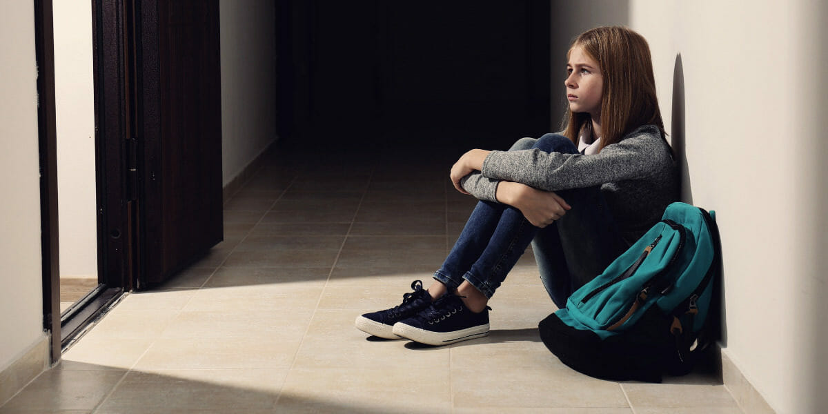 adolescente-avec-phobie-scolaire-assise-au-sol-a-l-ecole