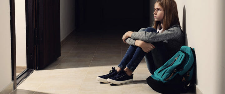 adolescente-avec-phobie-scolaire-assise-au-sol-a-l-ecole