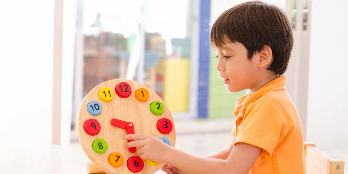 Little boy learning time with clock toy of montessori educationa