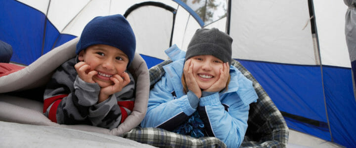 frere-et-soeur-heureux-dans-une-tente-en-camping